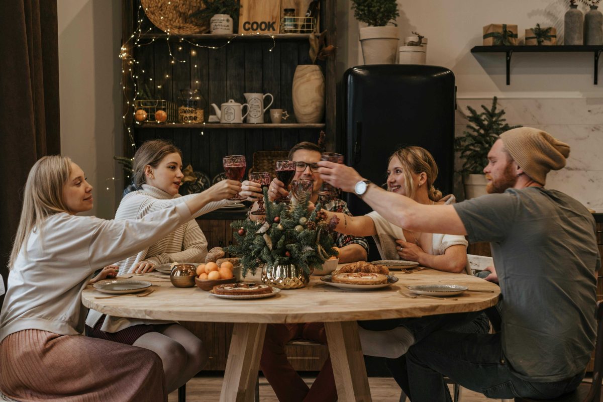 family and friends sitting around table enjoying meal together
